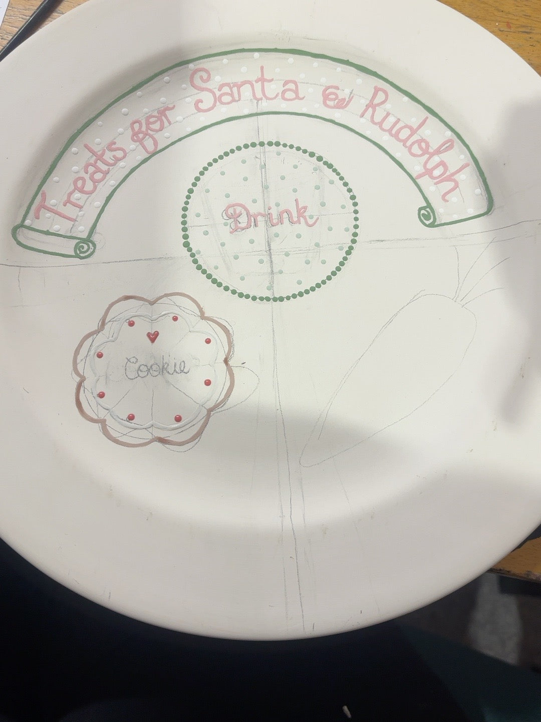 Christmas Eve ceramic plate in progress showing scalloped biscuit, raised white icing and red dots